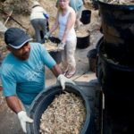 Lawrence Richardson (left) and Anna Creighton stack filled buckets of mulch in the bed of a truck as volunteers help fill more during a work day in Hapeville for Trees Atlanta on Saturday, June 23, 2012. Trees Atlanta is a citizens group that protects and improves Atlanta's urban forest by planting, conserving, and educating residents and volunteers. Since being founded in 1985, Trees Atlanta has planted over 88,000 shade trees in the metro area.