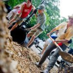 Barbara Park (right) shovels mulch into a bucket as Chris Liggett holds a bucket for Christian Bray during a volunteer work day in Hapeville for Trees Atlanta on Saturday, June 23, 2012. Trees Atlanta is a citizens group that protects and improves Atlanta's urban forest by planting, conserving, and educating residents and volunteers. Since being founded in 1985, Trees Atlanta has planted over 88,000 shade trees in the metro area.