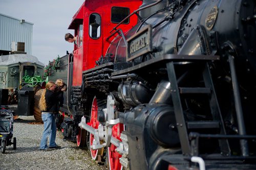 Brian Putnam (left) lifts his daughter onto a locomotive engine as his son Seth looks out of the window at the Southeastern Railway Museum in Duluth on Thursday, January 3, 2013.