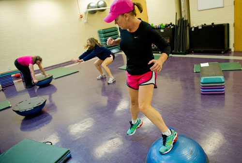 Renee Reddic performs exercises as trainer Shelby Katz demonstrates another exercise for Francoise Lama-Solet during a personal training class at the Robert D. Fowler YMCA in Peachtree Corners on Thursday, December 13, 2012. 
