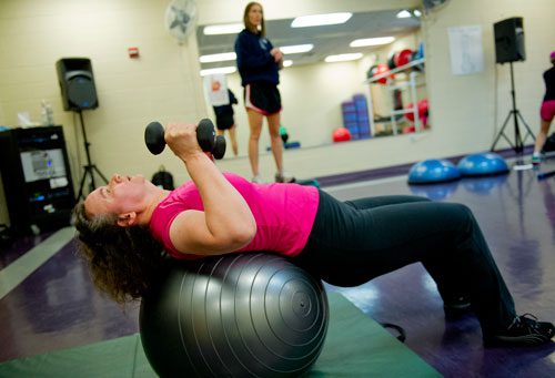 Francoise Lama-Solet (front) lifts weights over her head as trainer Shelby Katz gives instructions during a personal training class at the Robert D. Fowler YMCA in Peachtree Corners on Thursday, December 13, 2012. 