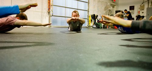 Andy Bayles leads his CrossFit class in warm up exercises at CrossFit Atlanta on Thursday, Decemeber 13, 2012.