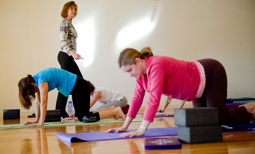 Betsy Blount walks through the rows of her students during a class at Plum Tree Yoga in Roswell on Friday, December 14, 2012. 