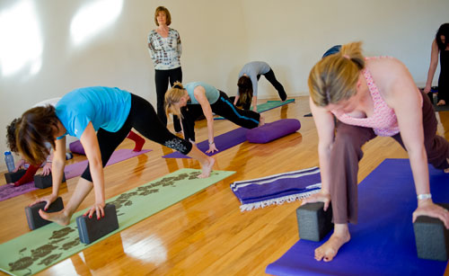 Betsy Blount (back center) watches her class move through a pose at Plum Tree Yoga in Roswell on Friday, December 14, 2012. 