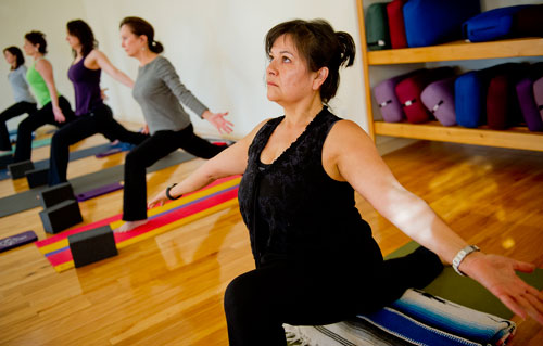 Kathy Knous (right), Dana Hilley, Renee Mango, Patti Sopko and Christy Aldredge hold a pose during a class at Plum Tree Yoga in Roswell on Friday, December 14, 2012. 