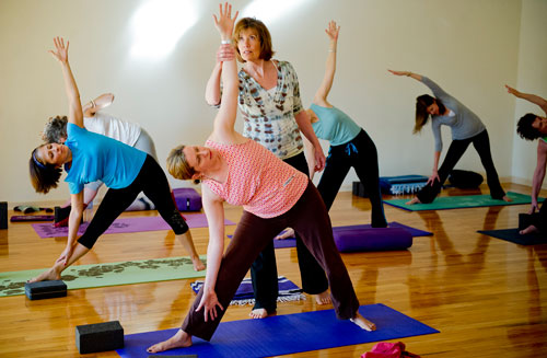 Betsy Blount (center) helps Susan Himmer slightly correct her pose during a class at Plum Tree Yoga in Roswell on Friday, December 14, 2012. 