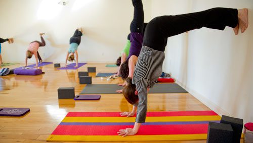 Dana Hilley balances her feet against the wall during a class at Plum Tree Yoga in Roswell on Friday, December 14, 2012.