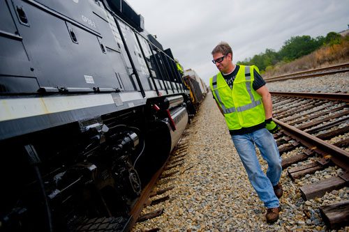 Locomotive engineer trainee Dale Maier performs a safety inspection before climbing aboard an engine at the Norfolk Southern Training Center in McDonough on Friday, January 11, 2013.