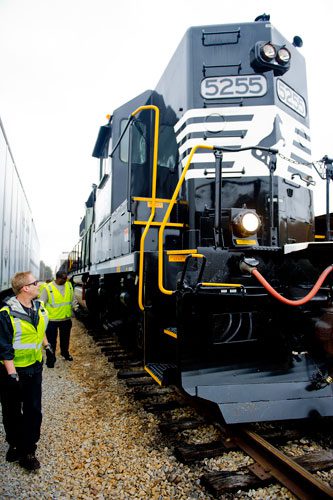 Locomotive engineer trainees Bob Cesare (left) and Carlos King perform a safety inspection before climbing aboard an engine at the Norfolk Southern Training Center in McDonough on Friday, January 11, 2013.