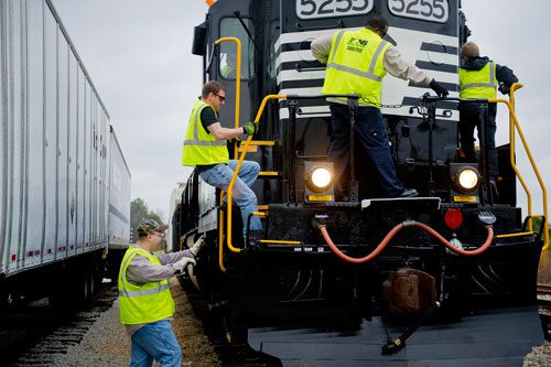 Locomotive engineer trainees Frank Geseck (left), Dale Maier, Carlos King and Bob Cesare climb aboard an engine after performing a safety inspection at the Norfolk Southern Training Center in McDonough on Friday, January 11, 2013. 