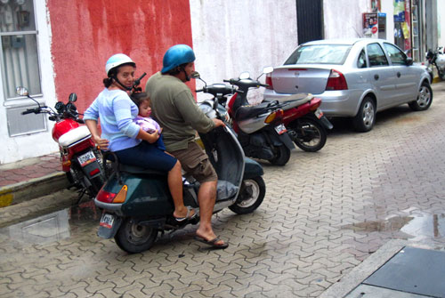 A family rides on a scooter as they navigate the streets of Isla Mujeres in Mexico on Thursday, January 24, 2013.
