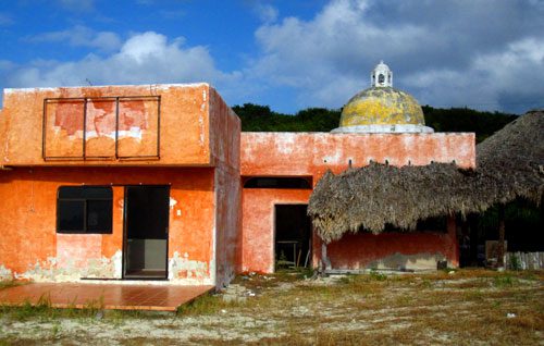 Old buildings damaged by hurricanes sit along the shore of Isla Mujeres in Mexico on Thursday, January 24, 2013.