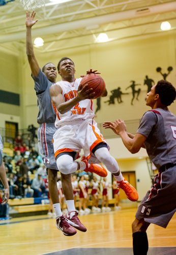 North Cobb's Lee Moore (center) goes up for two past Hillgrove's Johnathan James (left) and BJ Brown (right) during the AAAAAA Region 4 championship game on Saturday, February 16, 2013.