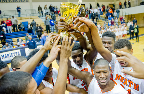 North Cobb's Jon Beausejour (canter) holds up the AAAAAA Region 4 trophy as he celebrates with Leon Jordan and the rest of their teammates after defeating Hillgrove 48-42 on Saturday, February 16, 2013. 