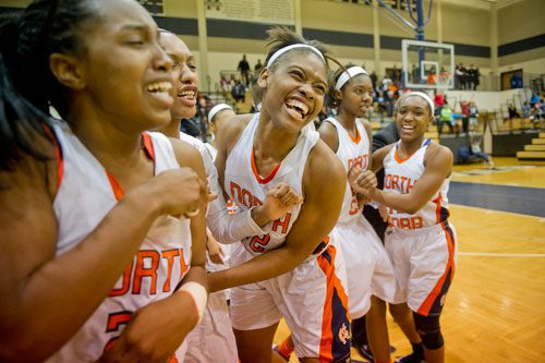 North Cobb's Amber Reeves (center) celebrates their 53-52 victory over McEachern claiming the Region 4 Championship with teammate Briah Woods (left) on Saturday, February 16, 2013.