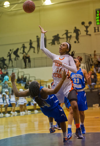 North Cobb's Alexis Luster (11) shoots for two as she collides with McEachern's Declaria Daniels (24) on Saturday, February 16, 2013.