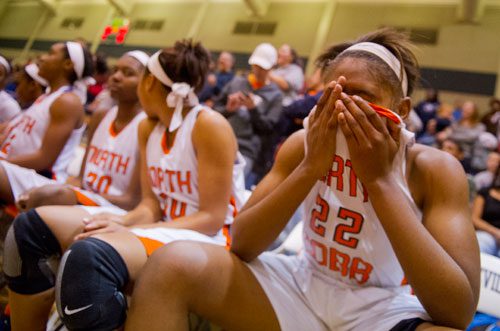 North Cobb's Amber Reeves (22) covers her face in her hands after a last minute victory over McEachern to win the AAAAAA Region 4 championship game on Saturday, February 16, 2013.