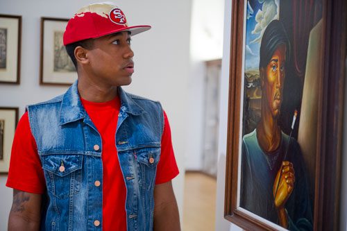 Jamal Brown looks at a painting entitled "Man with a Brush" by Frederick Flemister at the Clark Atlanta University Art Gallery on Wednesday, February 20, 2013. 