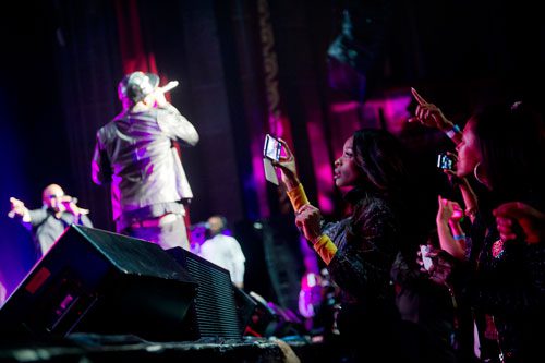 Shamea Morton (right) records Jagged Edge on her phone as they perform on stage at the Fox Theatre in Atlanta during the So So Def 20th Anniversary Concert on Saturday, February 23, 2013.  