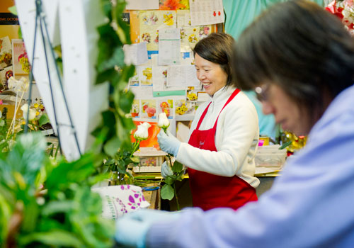 May Tsai (left) arranges flowers in a vase as Jihfang Liu arranges plants in a basket at A Blooming Earth florist shop in Decatur on Thursday, January 31, 2013.