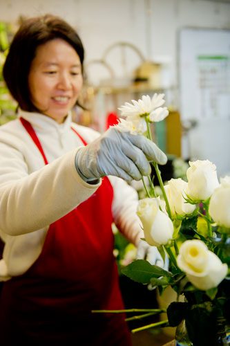  May Tsai arranges flowers in a vase at A Blooming Earth florist shop in Decatur on Thursday, January 31, 2013. 