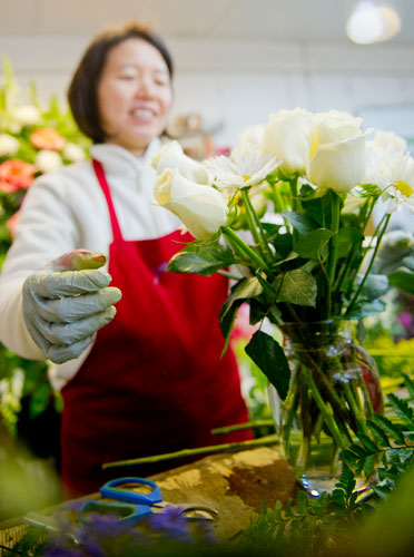 May Tsai arranges flowers in a vase at A Blooming Earth florist shop in Decatur on Thursday, January 31, 2013. 
