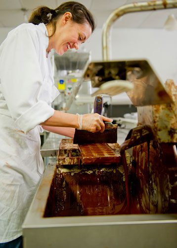 Bianca Garcia covers a mold filled with truffles with chocolate as she prepares for Valentine's Day at Cacao Atlanta in Inman Park on Friday, February 1, 2013. 