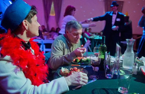 Marcy Stoll (left) and her husband Dave eat dinner as Virginia Kirby dances with Coleman Rudolph during the murder mystery dinner Death at the Doo Wop at Blue Mark Studios in Midtown on Tuesday, February 12, 2013. 