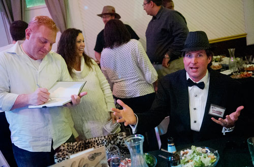Paul Misticawi (left) takes notes as his wife Gina interviews suspect Coleman Rudolph during the murder mystery dinner Death at the Doo Wop at Blue Mark Studios in Midtown on Tuesday, February 12, 2013. 