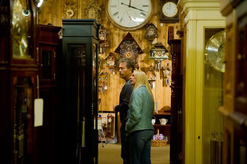 Derry Swan (left) and Shannon Britt look at one of the hundreds of grandfather clocks at Champ's Clock Shop in Douglasville during their fifth annual Chime Event on Saturday, March 9, 2013.