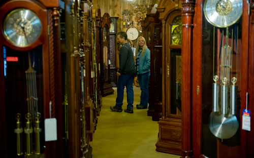 Derry Swan (left) and Shannon Britt look at one of the hundreds of grandfather clocks at Champ's Clock Shop in Douglasville during their fifth annual Chime Event on Saturday, March 9, 2013. 