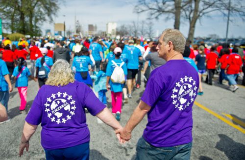June Woodside (left) holds hands with Donald Palguta as they walk in the Hunger Walk/Run 2013 through downtown Atlanta on Sunday, March 10, 2013.