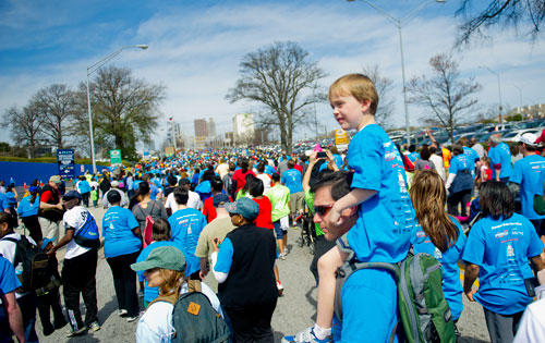 Mike McIntosh (center) carries his son James on his shoulders as they walk in the Hunger Walk/Run 2013 through downtown Atlanta on Sunday, March 10, 2013. 