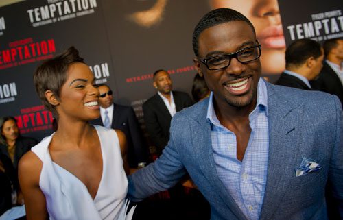 Tika Sumpter (left) is hugged by Lance Gross as they walk the red carpet for Tyler Perry's new movie Temptation at the AMC Parkway Pointe 15 theaters in Atlanta on Saturday, March 16, 2013. 