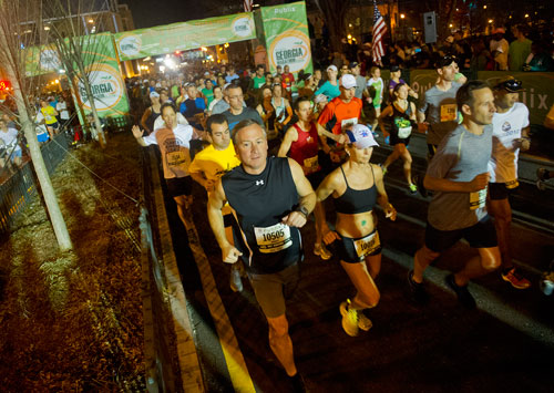 Warren Mowry (left) runs next to Paula May as they take off from the starting line during the 2013 Publix Georgia Marathon/Half Marathon in Atlanta on Sunday, March 17, 2013. 
