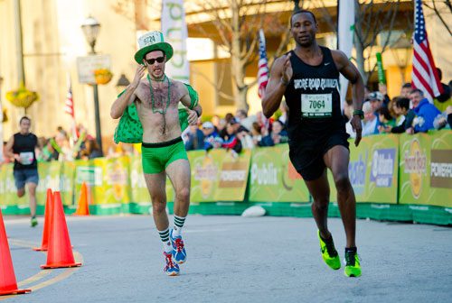 Marcus Lostracco (left) tries to catch Ron Dickson as they near the finish line during the 2013 Publix Georgia Marathon/Half Marathon in Atlanta on Sunday, March 17, 2013. 