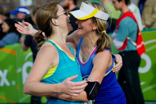 Michele Ocampo (left) is hugged by Alexandra White after they cross the finish line during the 2013 Publix Georgia Marathon/Half Marathon in Atlanta on Sunday, March 17, 2013. 
