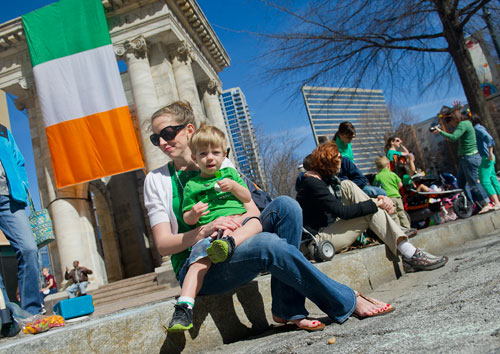 Tara Tanner (left) holds her son Nash as they wait for the start of the 131st Atlanta St. Patrick's Day Parade on Saturday March 16, 2013.