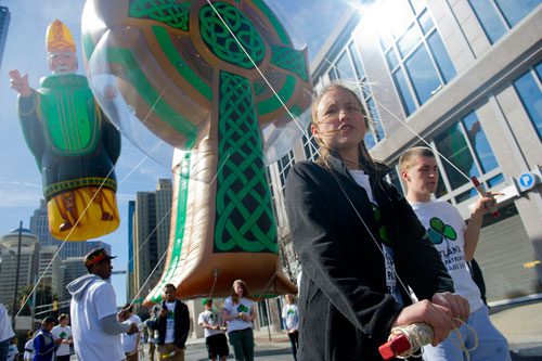Hannah Koenraad (center) and Graham White guide a balloon to the starting point for the 131st Atlanta St. Patrick's Day Parade on Saturday March 16, 2013. 