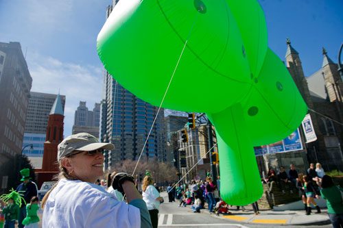 Karen Mack (left) guides a shamrock balloon down Peachtree Street during the 131st Atlanta St. Patrick's Day Parade on Saturday March 16, 2013. 