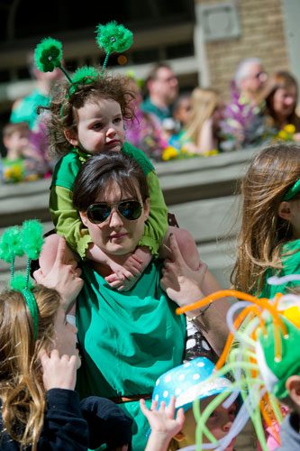 Elizabeth Martin (center) holds Lilla Hand on her shoulders as they watch the 131st Atlanta St. Patrick's Day Parade march down Peachtree Street on Saturday March 16, 2013.