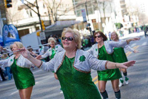 Kathy Prough (center), a member of the Twilight Twirlers, marches down Peachtree Street during the 131st Atlanta St. Patrick's Day Parade on Saturday March 16, 2013.