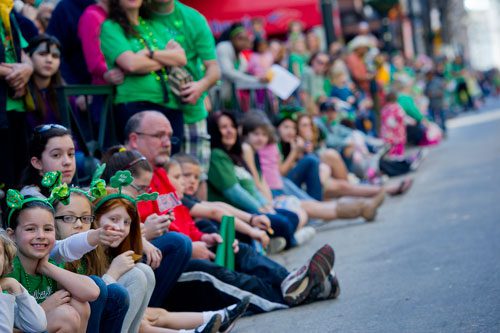 Grace Eigel (left), Rachel Schmidt and Grace Goodman watch the festivities during the 131st Atlanta St. Patrick's Day Parade on Saturday March 16, 2013.