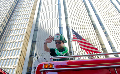 Jeremy Adams waves to the crowd atop a fire engine from Roswell during the 131st Atlanta St. Patrick's Day Parade on Saturday March 16, 2013. 