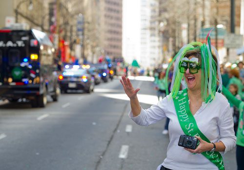 Carolyn Scruggs (right) waves to parade participants as they march down Peachtree Street during the 131st Atlanta St. Patrick's Day Parade on Saturday March 16, 2013. 