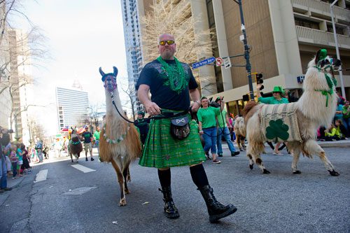  Liam Munroe (center) leads his llama Echo down Peachtree Street during the 131st Atlanta St. Patrick's Day Parade on Saturday March 16, 2013.