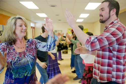 Bobbi Gruber (left) and Hans Williams learn to contra dance during the Stone Mountain Village Blue Grassroots Music and Arts Festival on Saturday, March 23, 2013.