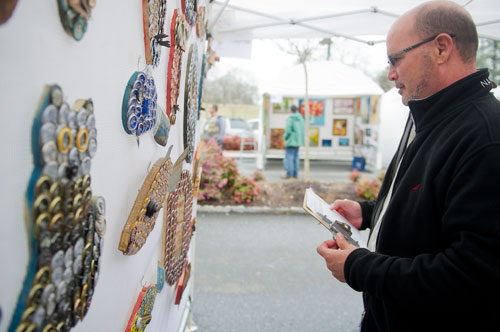 David Thomas looks at Donna DiGiorgio's artwork as he judges the Stone Mountain Village Blue Grassroots Music and Arts Festival on Saturday, March 23, 2013.