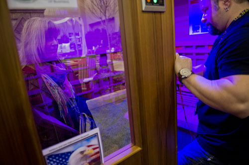 Michael Willis (right) talks with Fred Ricciardello as he lays in a sauna during the 35th Annual Spring Atlanta Home Show at the Cobb Galleria Center in Atlanta on Saturday, March 23, 2013.