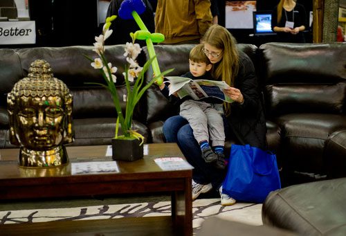 Ilka Nickolov (right) holds her son Danny as they look at a brochure during the 35th Annual Spring Atlanta Home Show at the Cobb Galleria Center in Atlanta on Saturday, March 23, 2013. 